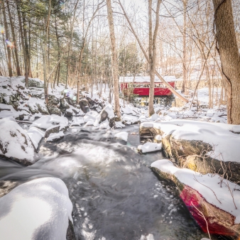 Winter scene of covered bridge in distance at Southford Falls (CTvisit)
