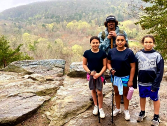 Children hiking with adult on rock with scenic view in background (Instagram@kleelee19_0)